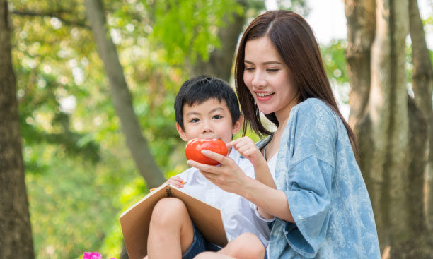 Mom-and-boy-kid-read-book-in-field