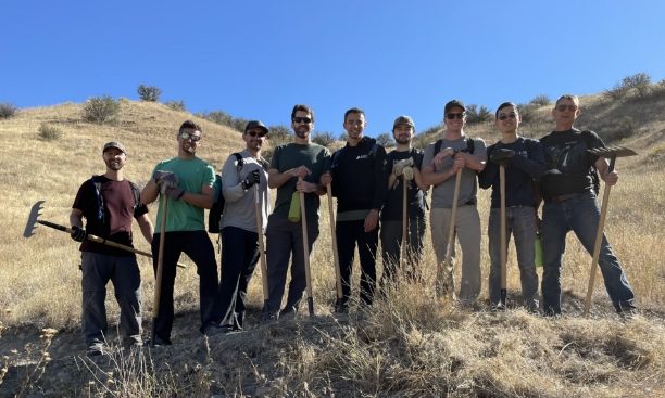 A group photo of people with shovels