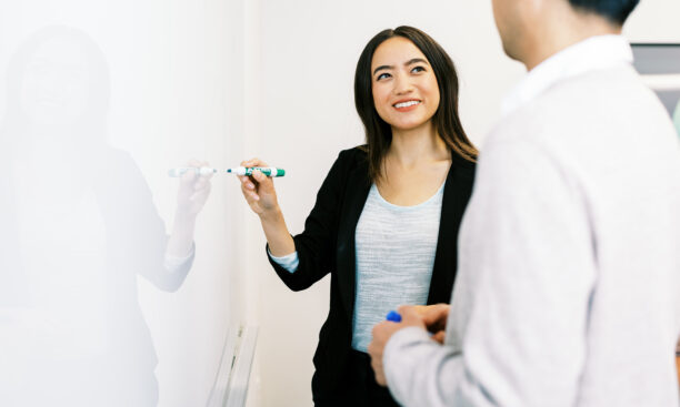 Business Women chatting in front of white board